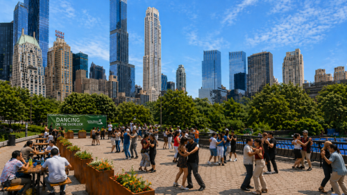 Couples dancing on The Overlook at Wollman Rink on a sunny evening, with the skyline behind.